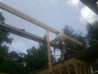 Carpenter setting a ridge beam over a new addition frame — Ice Dam Removal by Roofing Brothers in Avon By The Sea