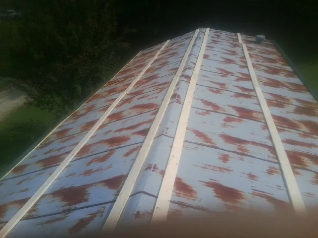 Rusted metal roof panels with new wood purlins before replacement — Storm Damage Roof Repair in Avon By The Sea by Roofing Brothers