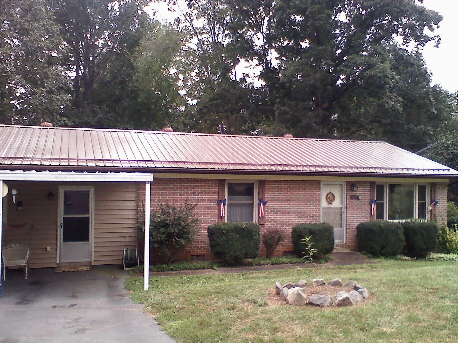 Bronze metal roof and carport on a brick ranch home — Roof Repair work by our crew in Avon By The Sea